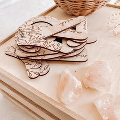 Stack of wooden coasters with laser-cut designs on a light surface