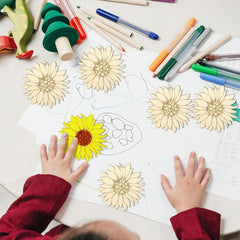 Children's hands coloring sunflowers on a piece of paper with markers and crayons.