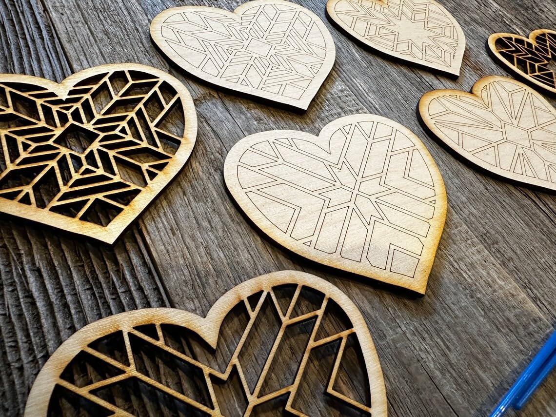 Heart-shaped wooden cutouts with geometric patterns on a wooden surface