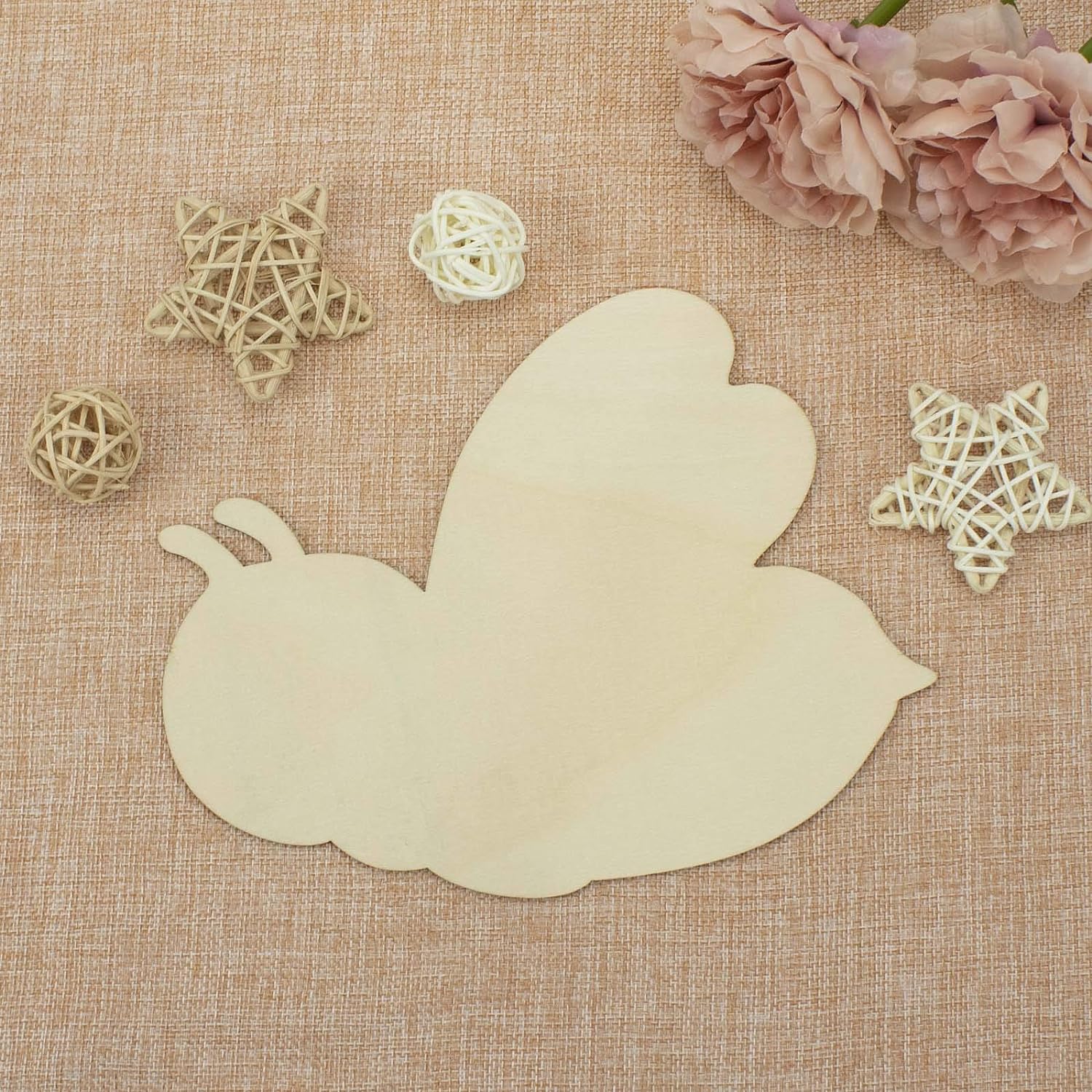 Beige leaf-shaped decorative item on a textured beige surface with decorative stars and flowers.