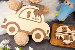 Wooden baby milestone car toys with numbers on a textured surface.
