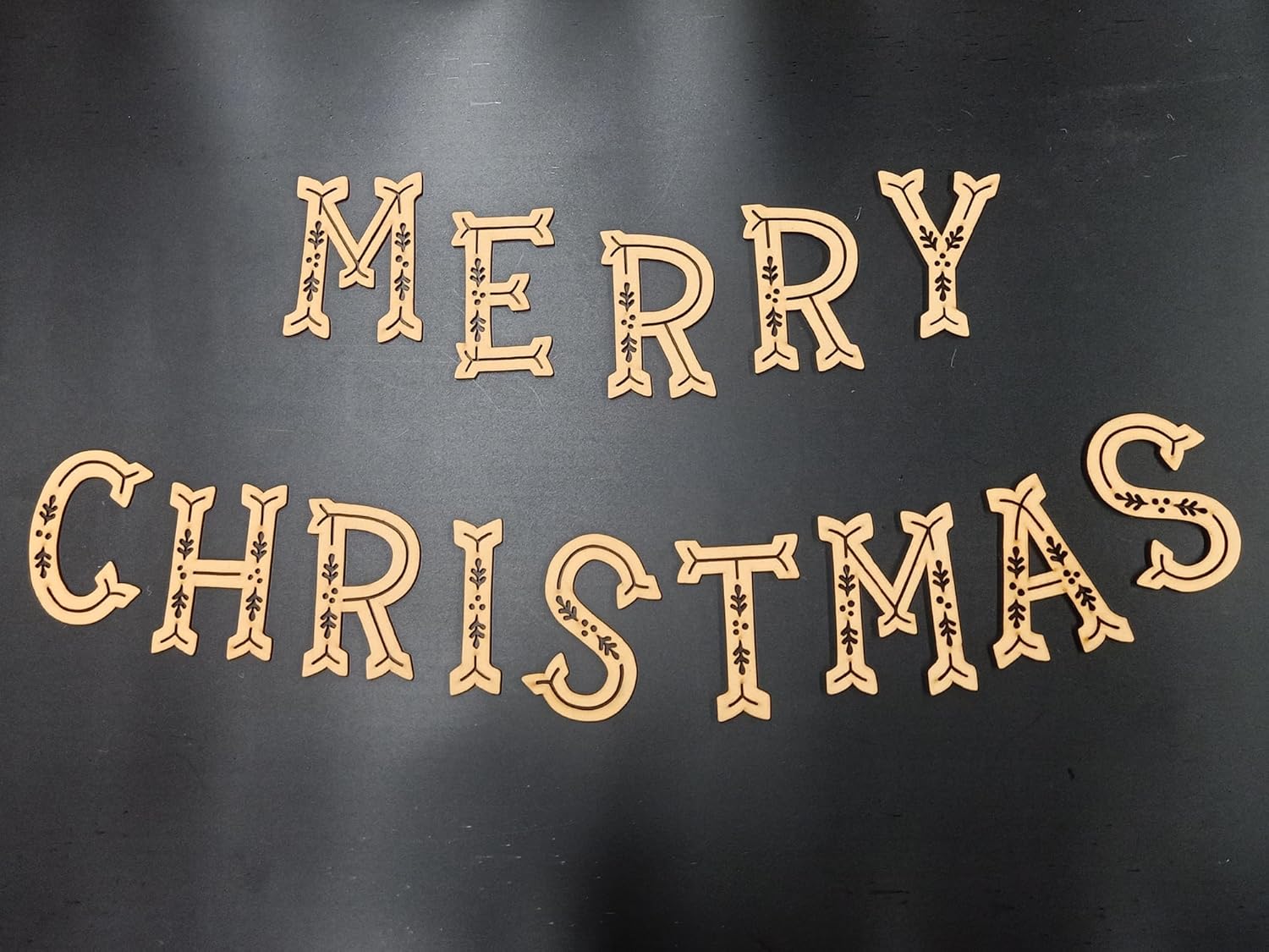 Wooden 'Merry Christmas' decoration on a black background