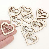 Wooden heart-shaped decorations with 'love' engraving on a white background