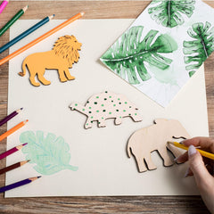 Children's craft activity with animal cutouts and colored pencils on a wooden table.