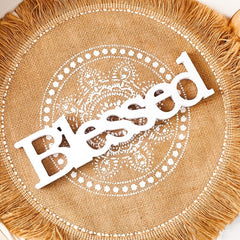Round woven mat with 'Blessed' text in the center, surrounded by decorative patterns.