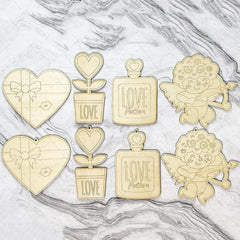 Set of gold-themed decorative items including hearts, plants, and angels on a marble surface.