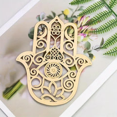 Decorative gold Hamsa hand pendant on a floral background