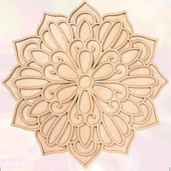 Decorative wooden mandala with intricate patterns on a light pink background