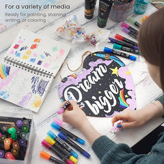 Person working on a craft project with markers and art supplies on a table.