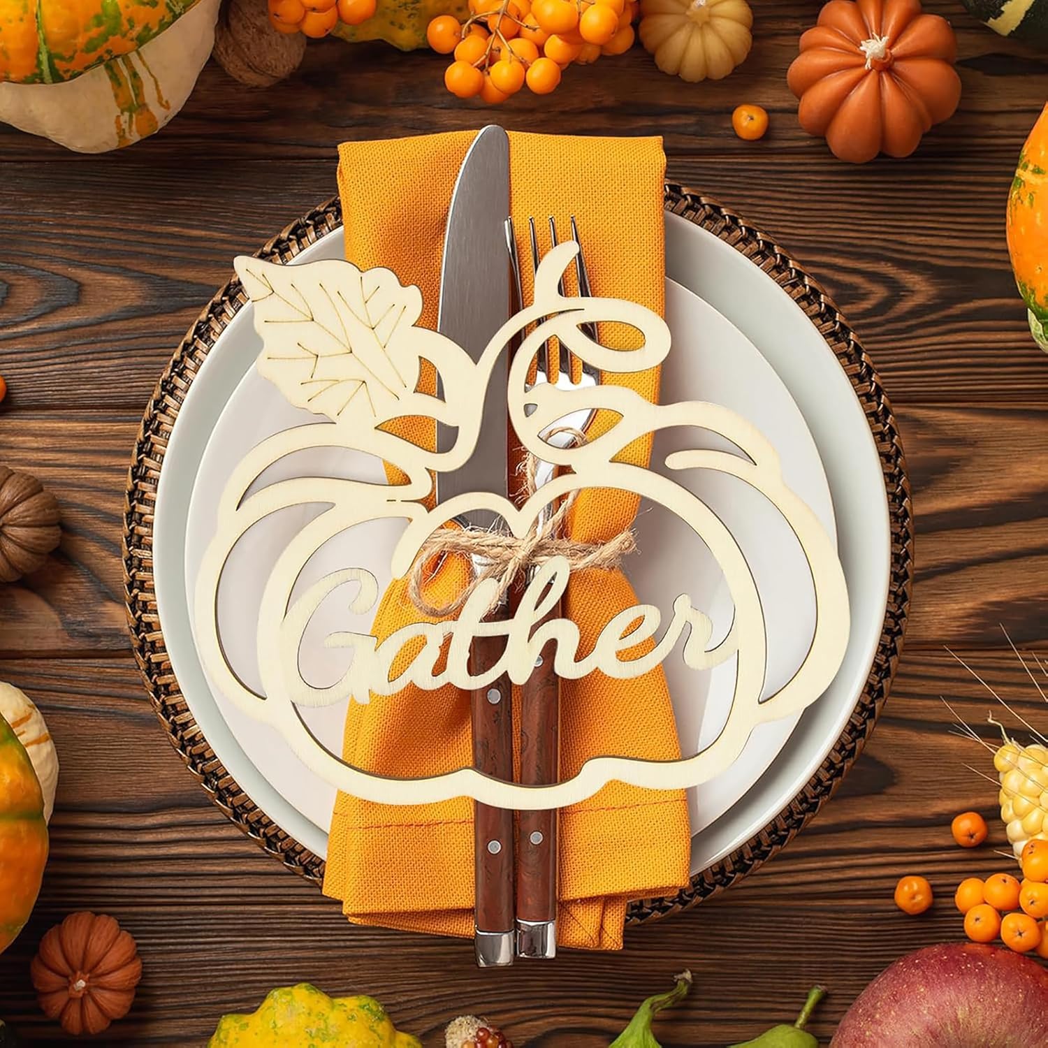 Thanksgiving table setting with pumpkins, corn, and a decorative place card on a wooden table.