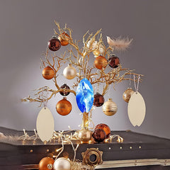 Decorative tree with ornaments and lights on a dark surface