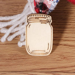 Wooden mason jar ornament on a wooden surface with white yarn in the background
