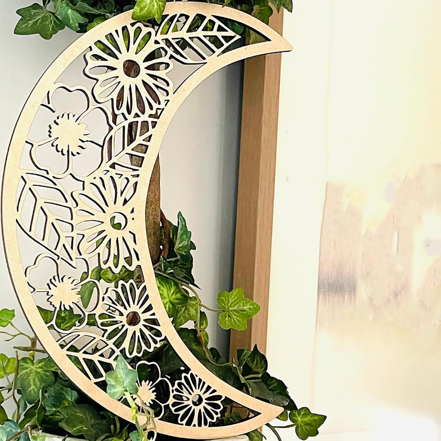 Decorative wooden moon with floral patterns on a white background
