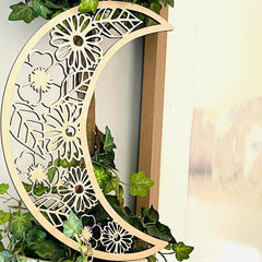 Decorative wooden moon with floral patterns on a white background