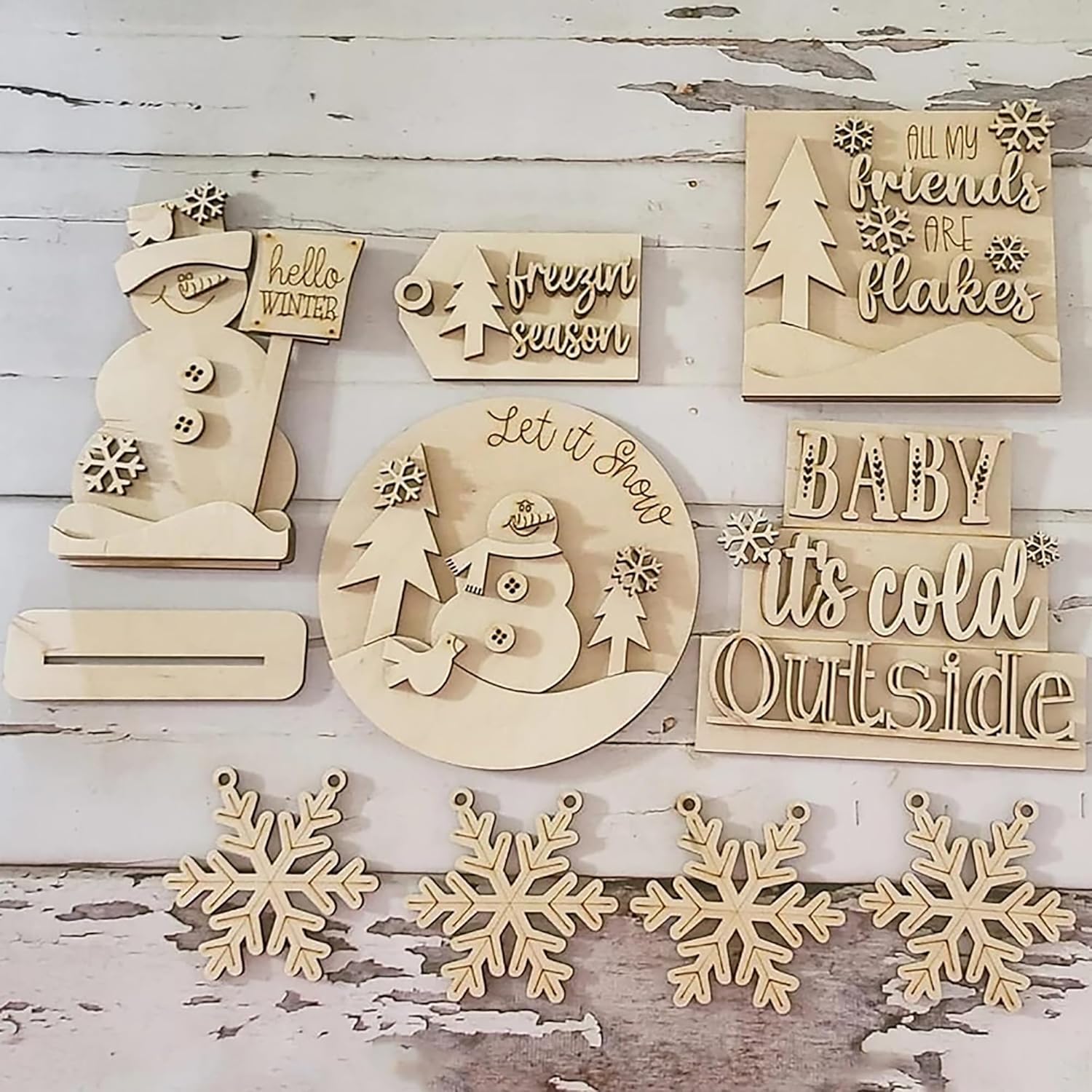 Set of wooden Christmas decorations with text and snowflake designs on a rustic wooden background.