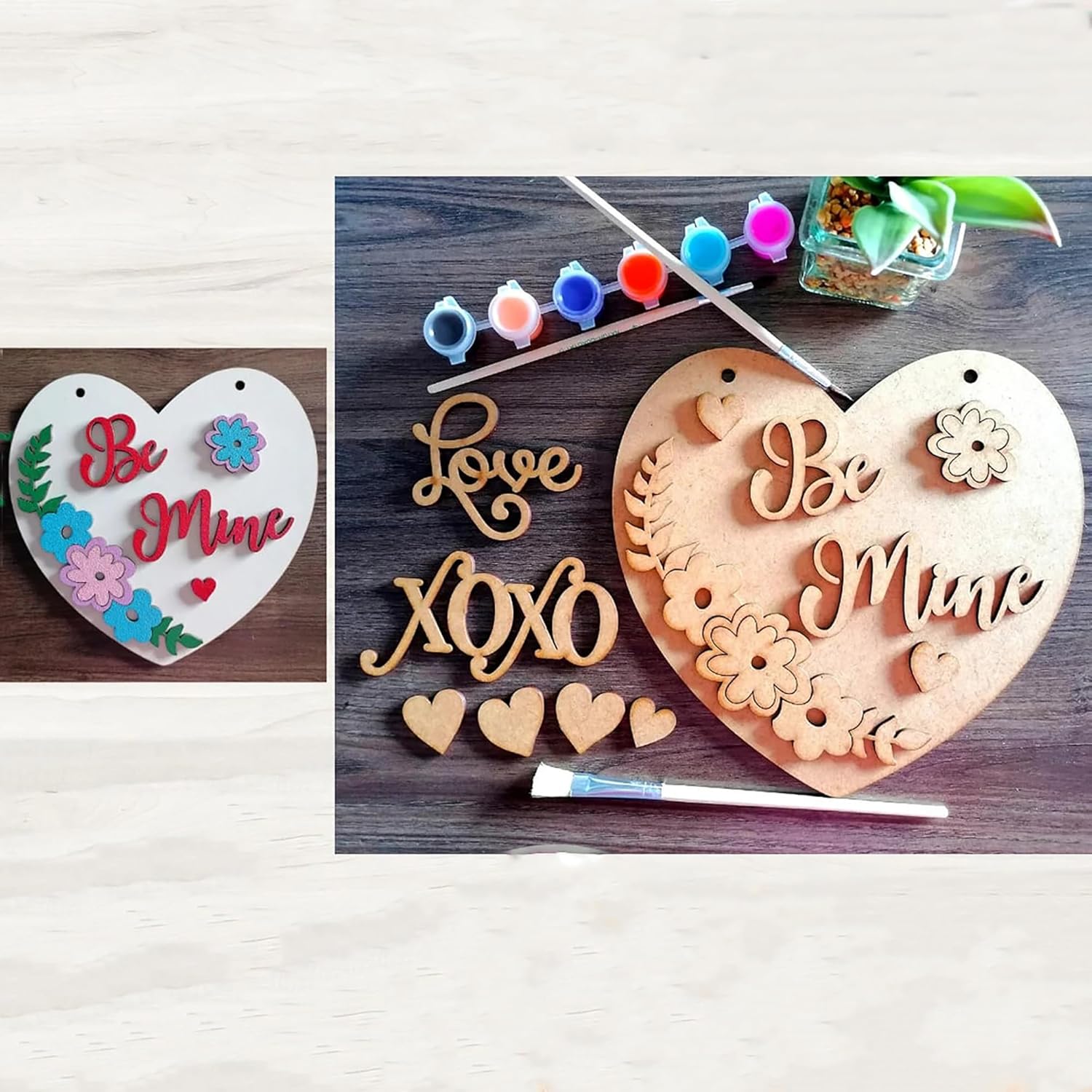Heart-shaped wooden signs with 'Be Mine' and 'Love XOXO' text, surrounded by paint supplies on a wooden surface.