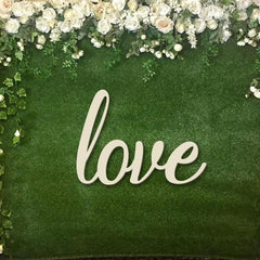 Decorative sign with 'love' on a green background with floral border