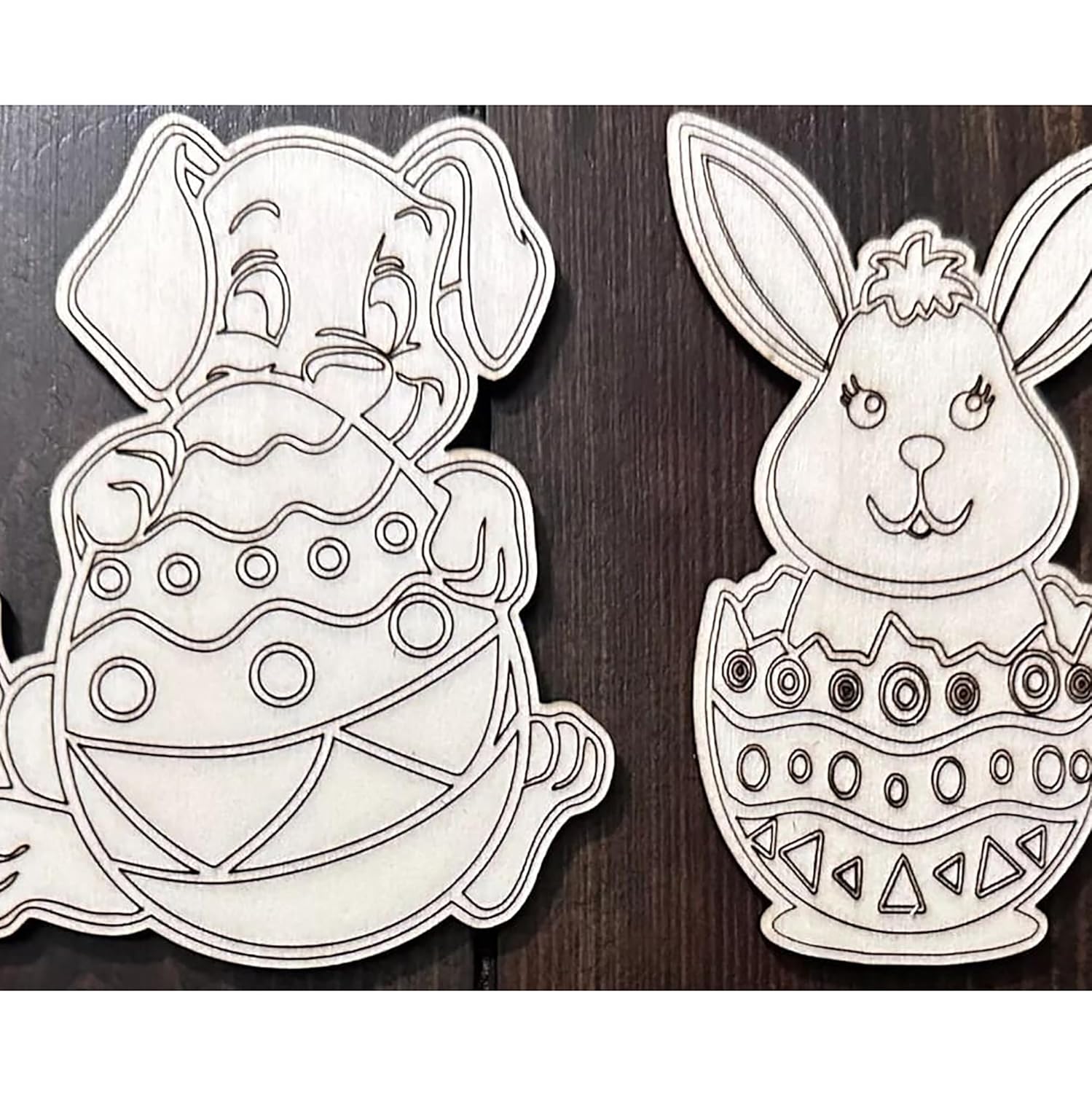 Two black and white bunny and egg designs on a wooden background