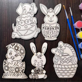 Set of Easter-themed coloring pages with paintbrushes and paint on a wooden surface