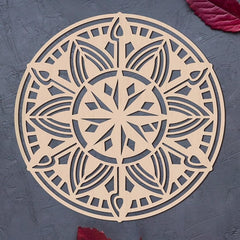 Decorative mandala cutout on a textured gray surface