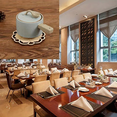 Ceramic pot on a wooden surface with a restaurant interior in the background