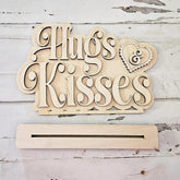 Wooden decorative sign with 'Hugs & Kisses' text on a rustic wooden background