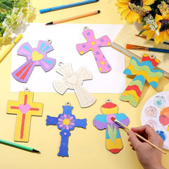 Colorful cross-shaped crafts on a yellow surface with painting tools and sunflowers.