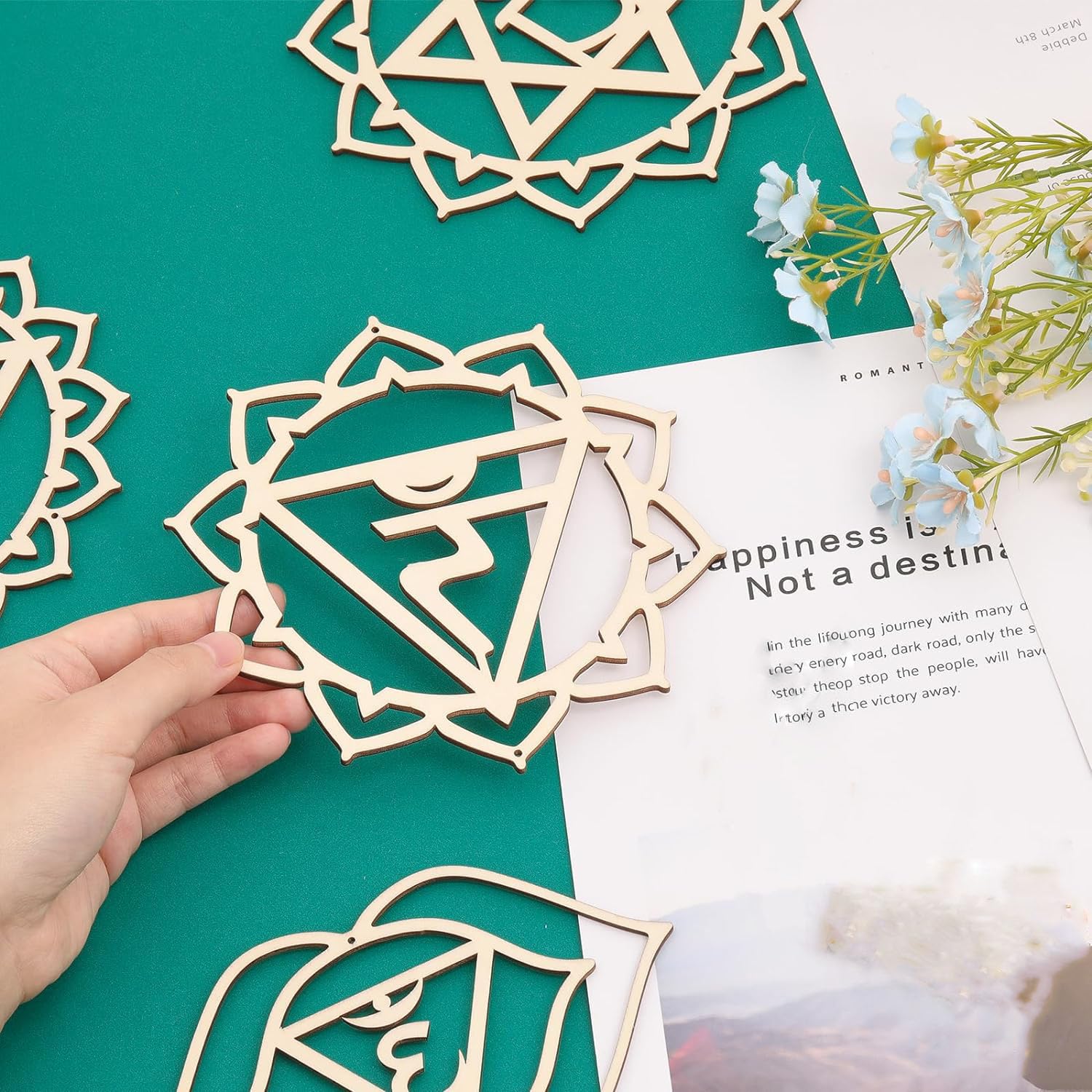 Wooden decorative pieces on a green surface with text and flowers