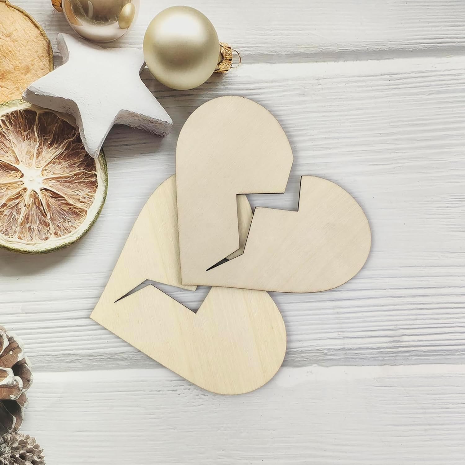 Wooden letter 'L' on a light wooden surface with Christmas decorations.