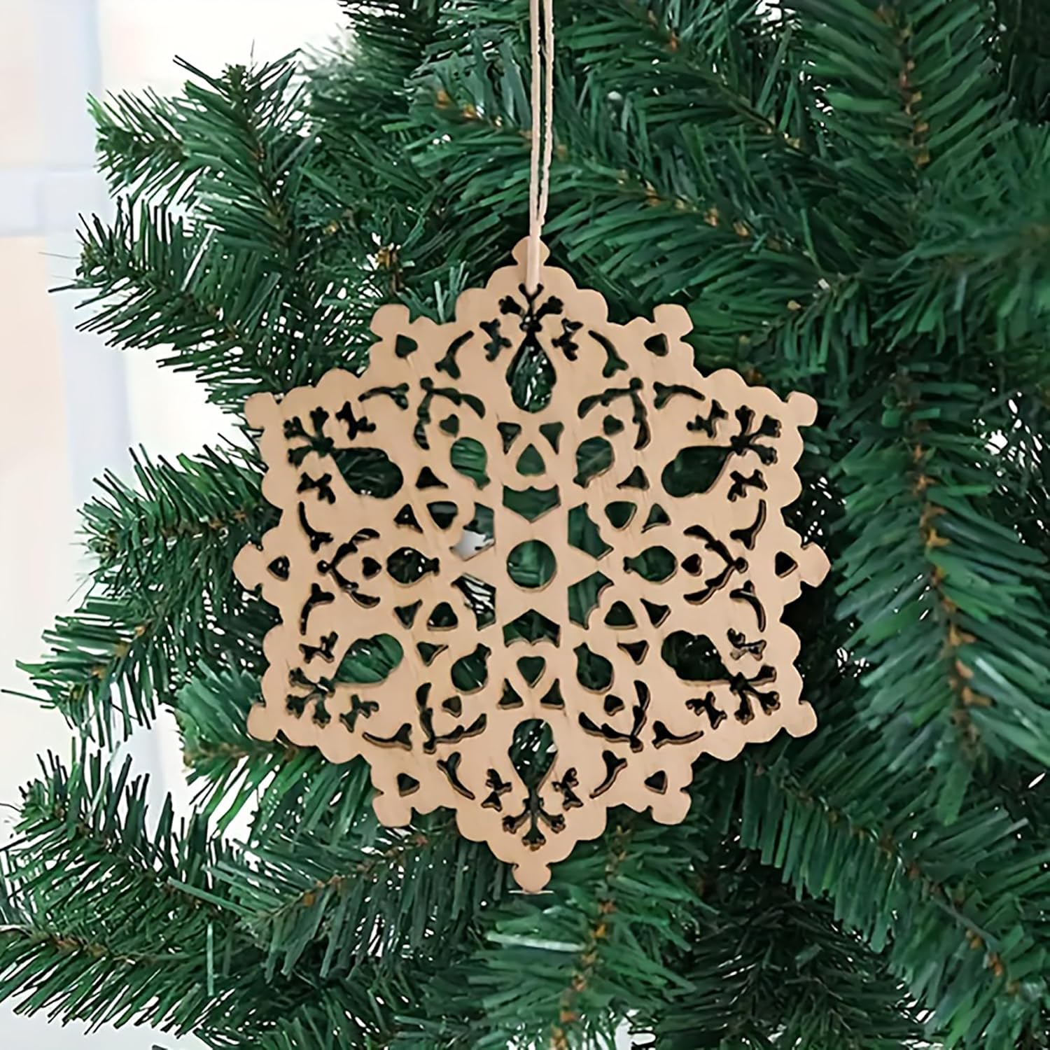 Decorative snowflake ornament hanging on a Christmas tree