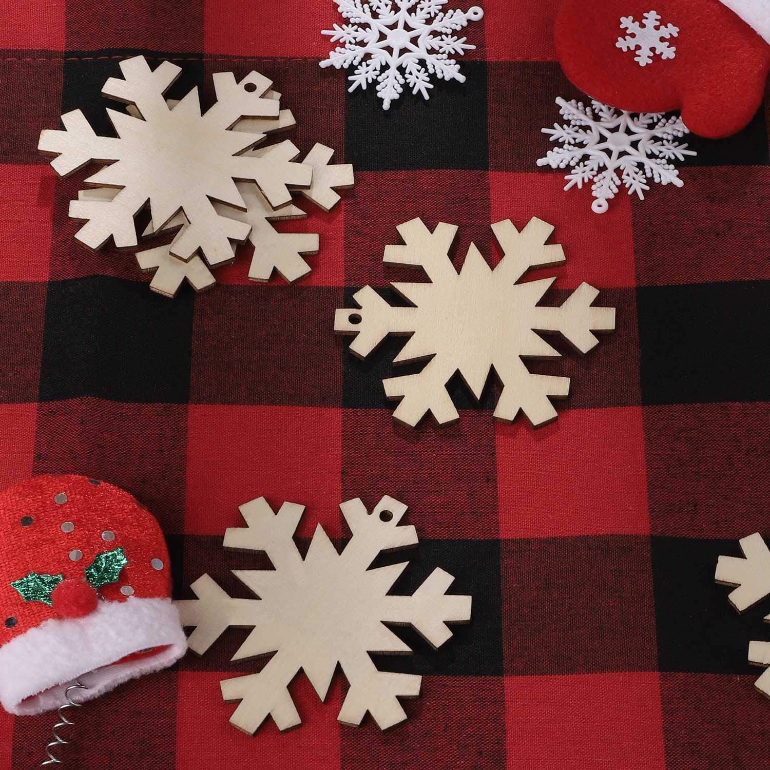 Wooden snowflakes and red mittens on a red and black checkered background