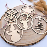 Wooden Christmas ornaments with snowflake, star, deer, and tree designs on a wooden surface.