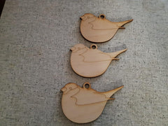 Three wooden bird-shaped ornaments on a textured surface