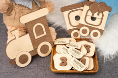 Wooden toy train with age milestone cards on a textured surface