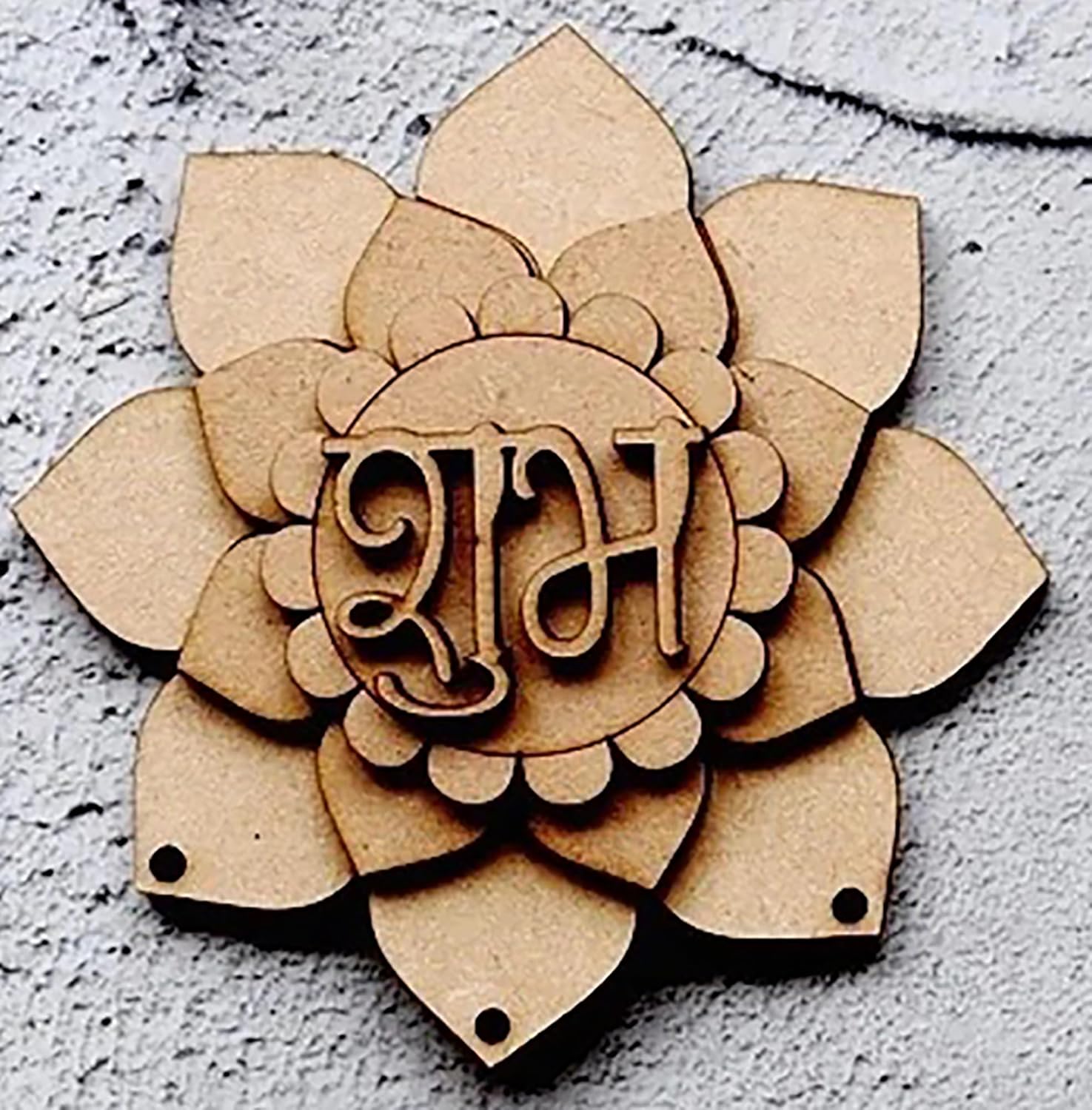 Wooden flower-shaped decoration with engraved letters on a textured surface