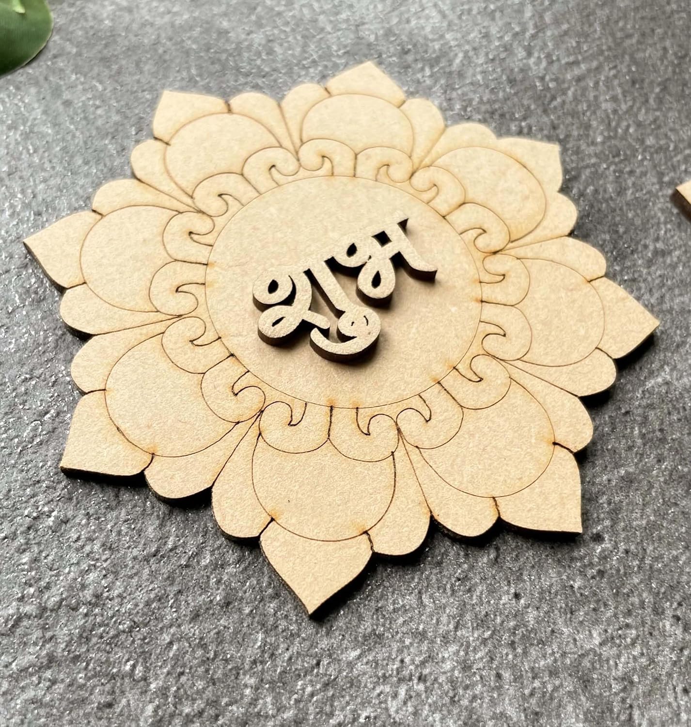 Decorative wooden piece with intricate patterns and 'Allah' text on a gray surface