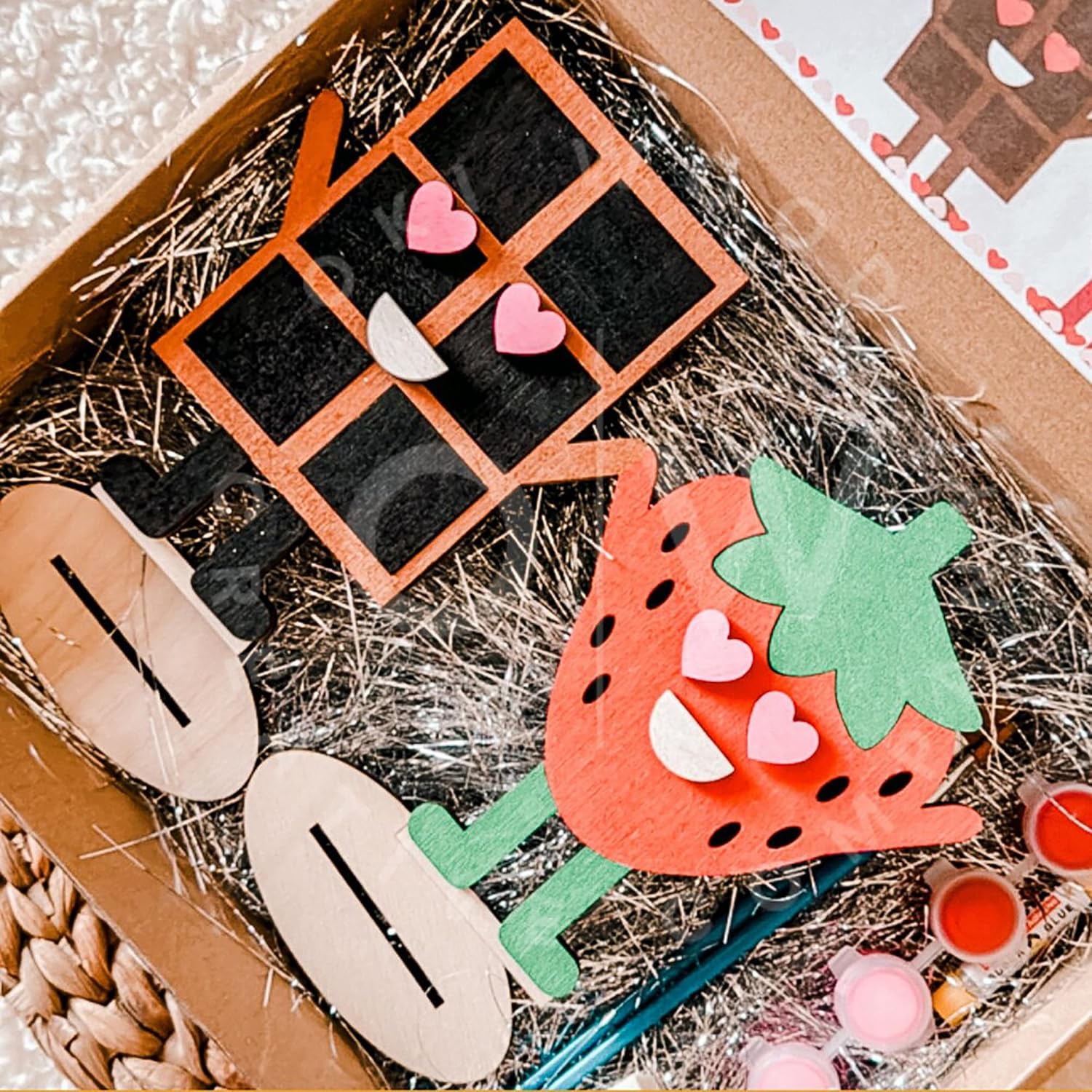Decorative items including a strawberry-shaped mirror and heart-shaped earrings in a box.