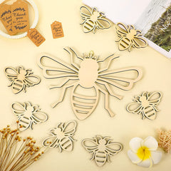 Wooden bee-shaped decorations on a beige surface with flowers and cards.