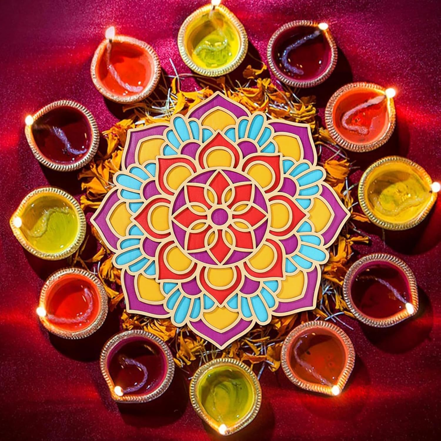 Colorful mandala with lit oil lamps on a red background