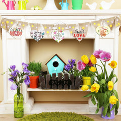 Decorative shelf with flowers, birdhouse, and bunting in a home setting