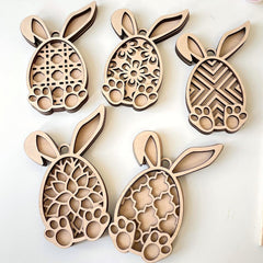 Wooden bunny-shaped cutouts with intricate patterns on a white background