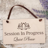 Decorative sign with a lotus flower symbol and text on a wooden background