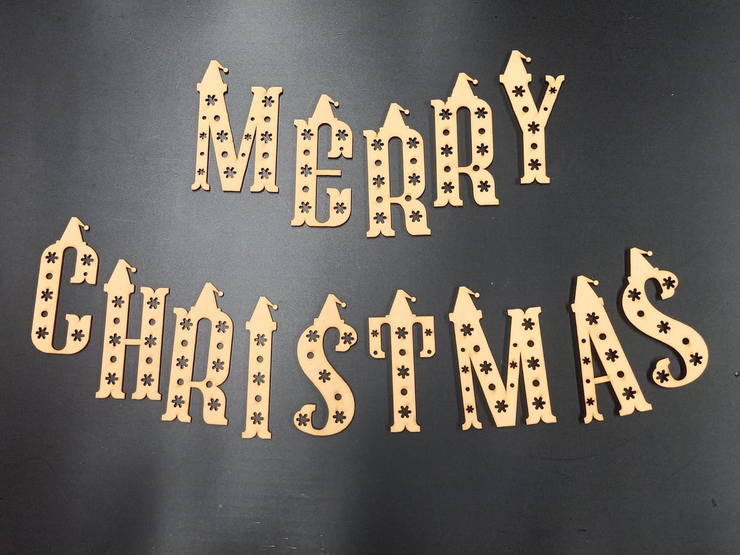 Wooden 'Merry Christmas' decoration on a black background