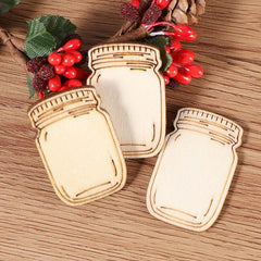 Wooden mason jar ornaments on a wooden surface with berries and pine cones.
