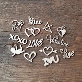 Wooden cutouts with heart and love-themed designs on a wooden surface