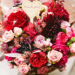 Bouquet of red and pink flowers with a 'Thank you' heart-shaped card.