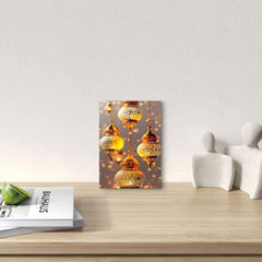 Decorative wall art with gold lanterns on a wooden surface with books and a green apple.
