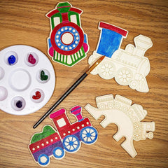 Colorful train-shaped wooden toys with a paint palette and brush on a wooden surface