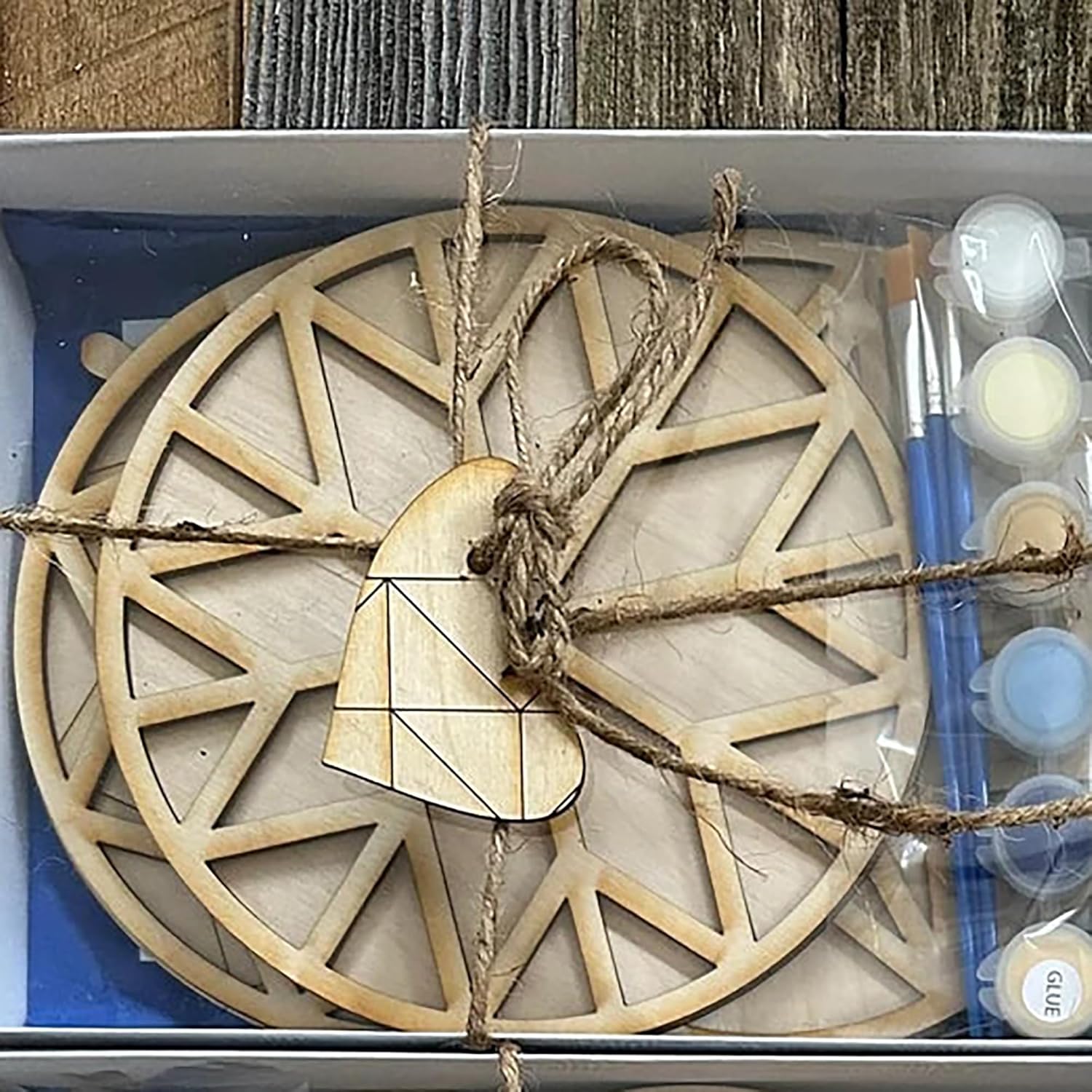 Wooden decorative item with rope and paint supplies in a box