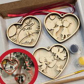 Heart-shaped wooden ornaments with paint supplies on a gray surface